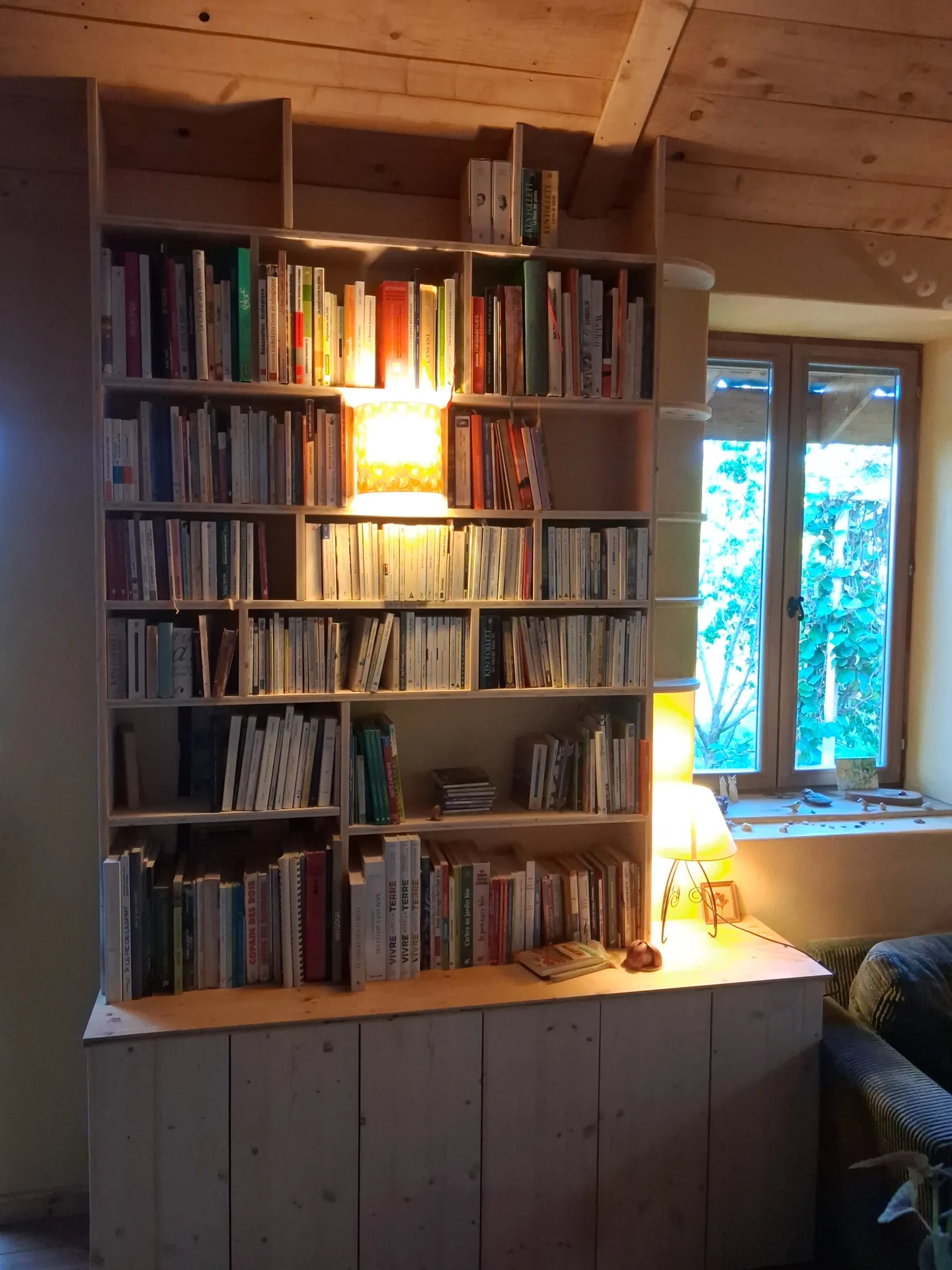 The bookcase in the evening: the light built into the central compartment shines from the front of the piece