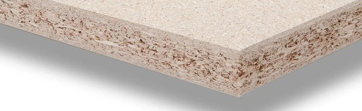 Edge of a raw chipboard panel, wood particles visible