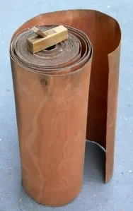 Log being peeled, the sheet of wood unrolling continuously