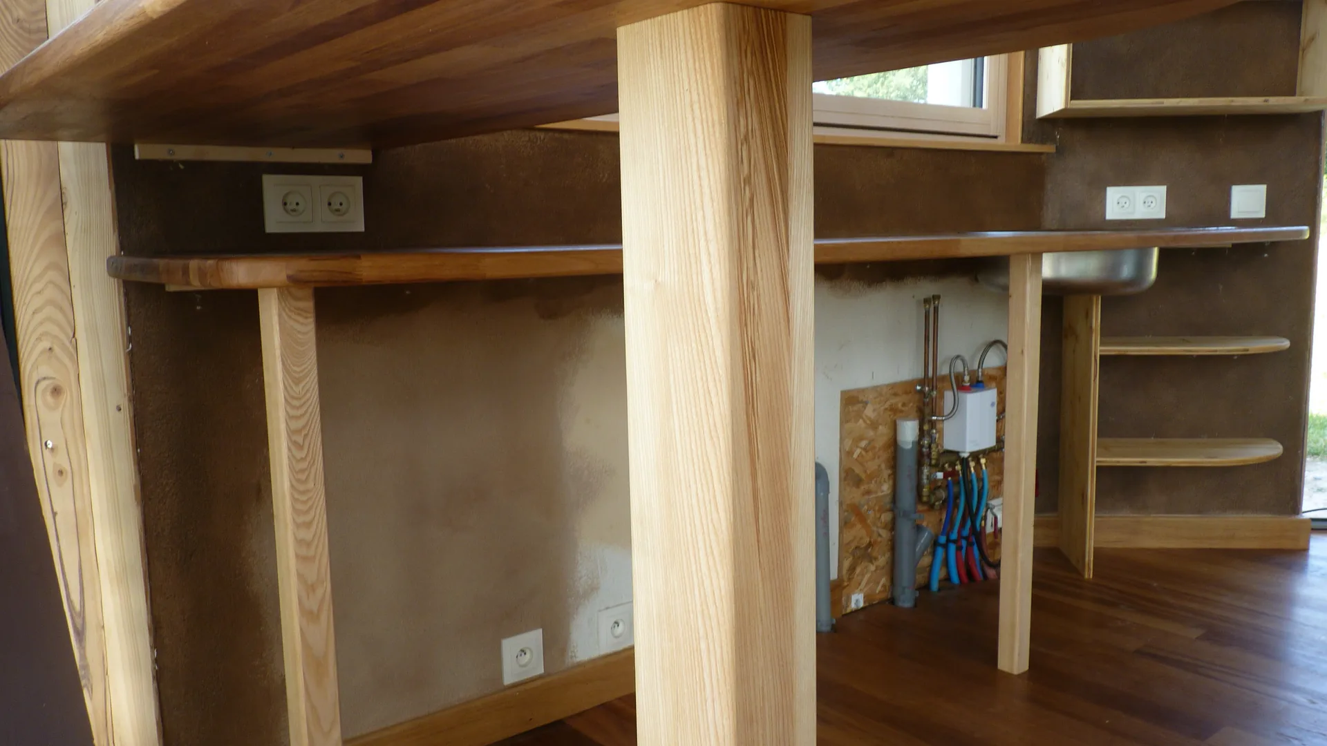 The structure seen from below: solid ash legs and post, not a single cabinet