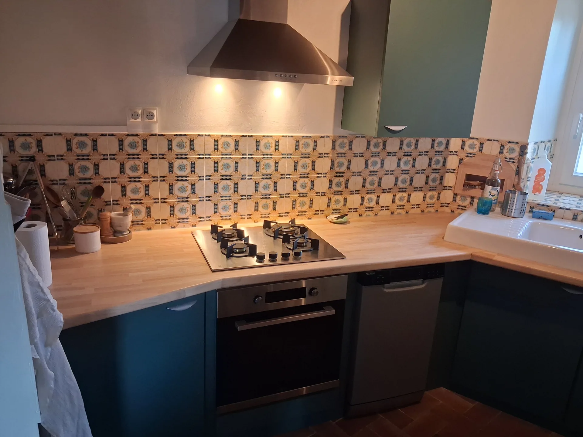 Bespoke U-shaped kitchen in Orignac: painted fronts, solid hevea worktop, original wall tiles kept