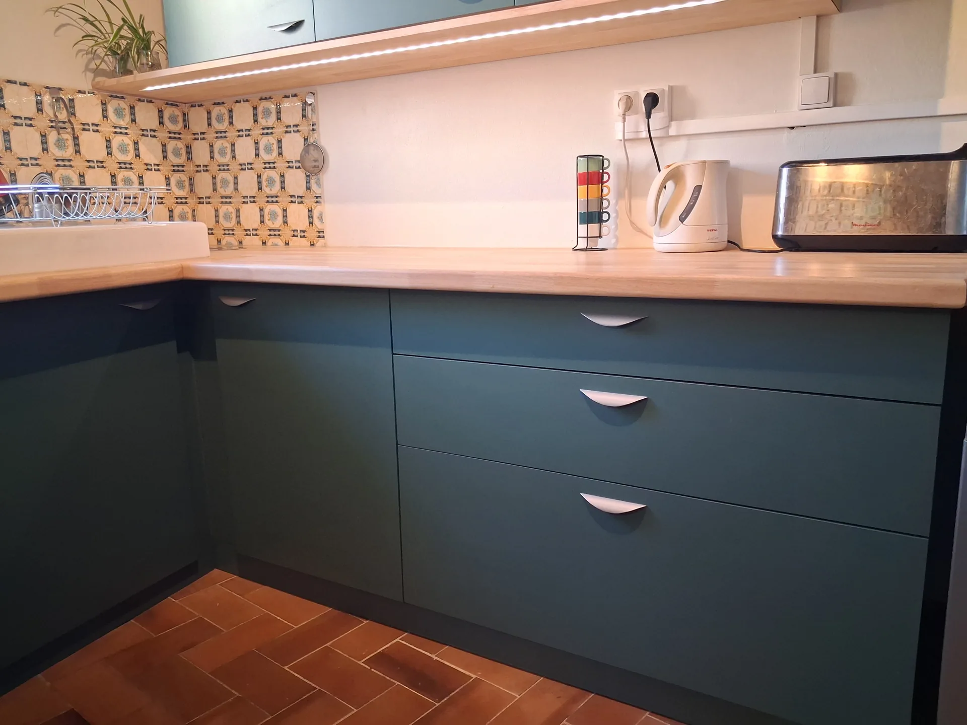 The corner of the U: solid hevea worktop running along the painted fronts