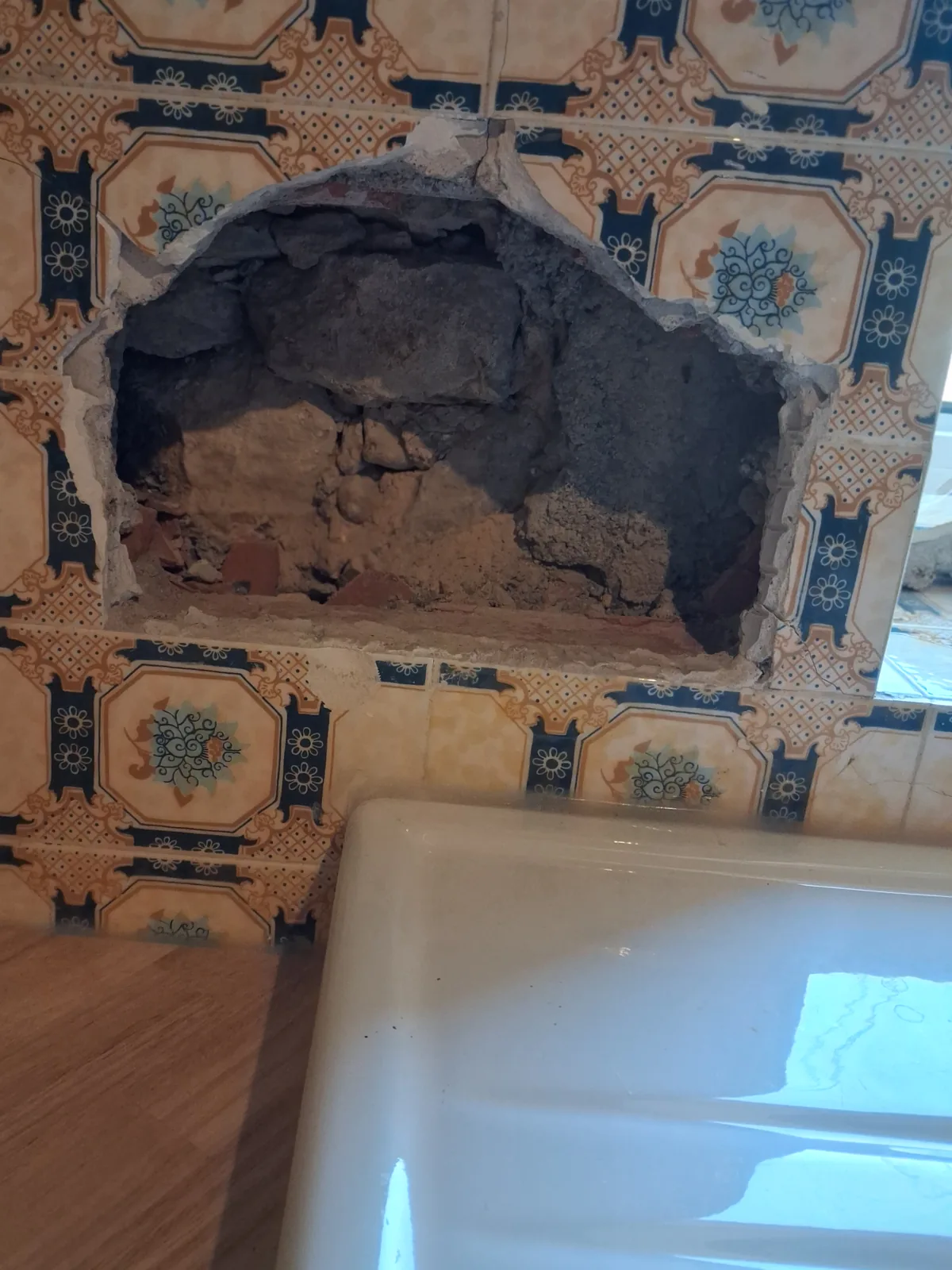 The opening in the wall above the sink, after removing the old broken glass block