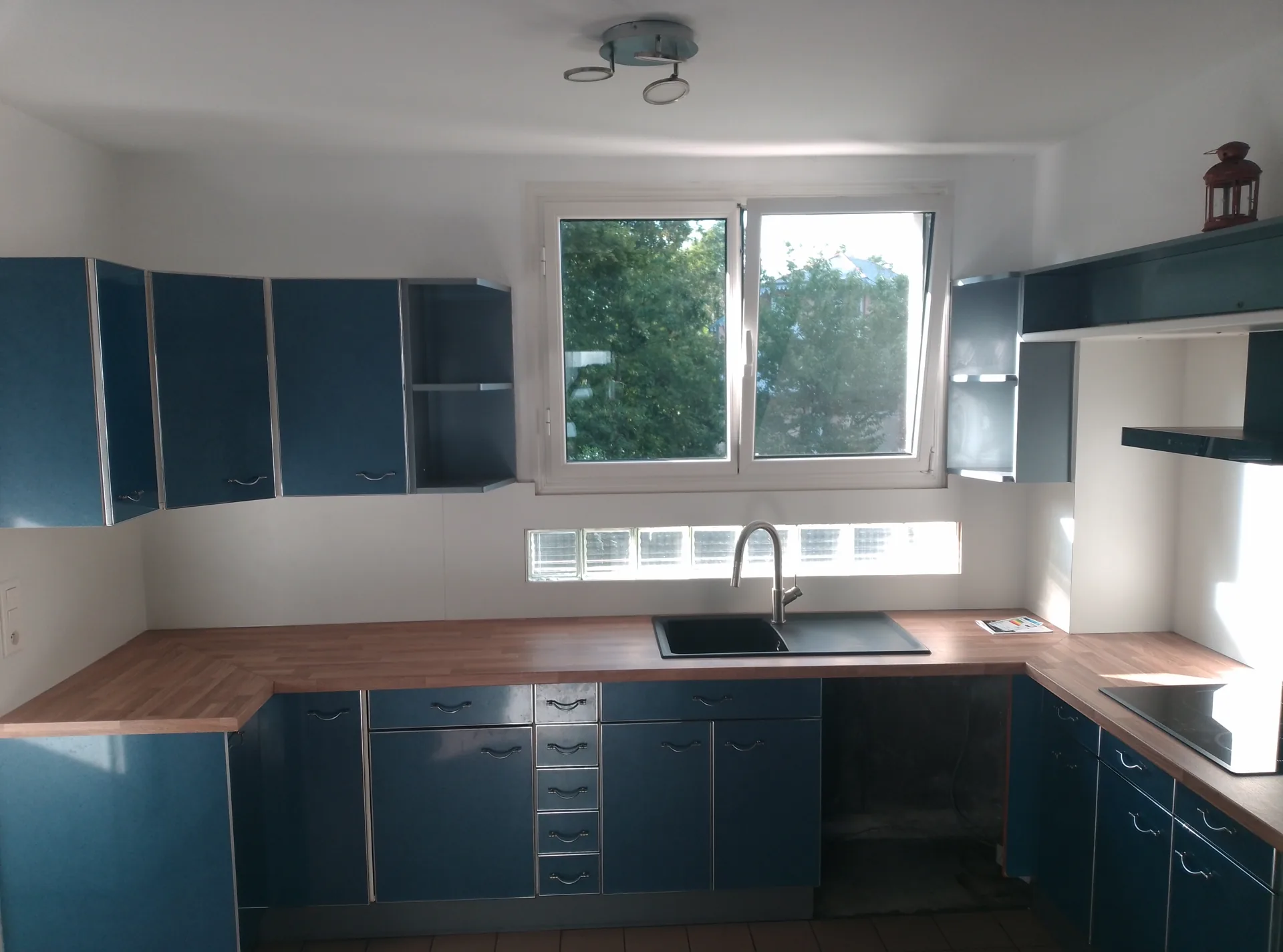 The renovated kitchen: oak-effect worktops, white splashback and the glass light panes kept in place