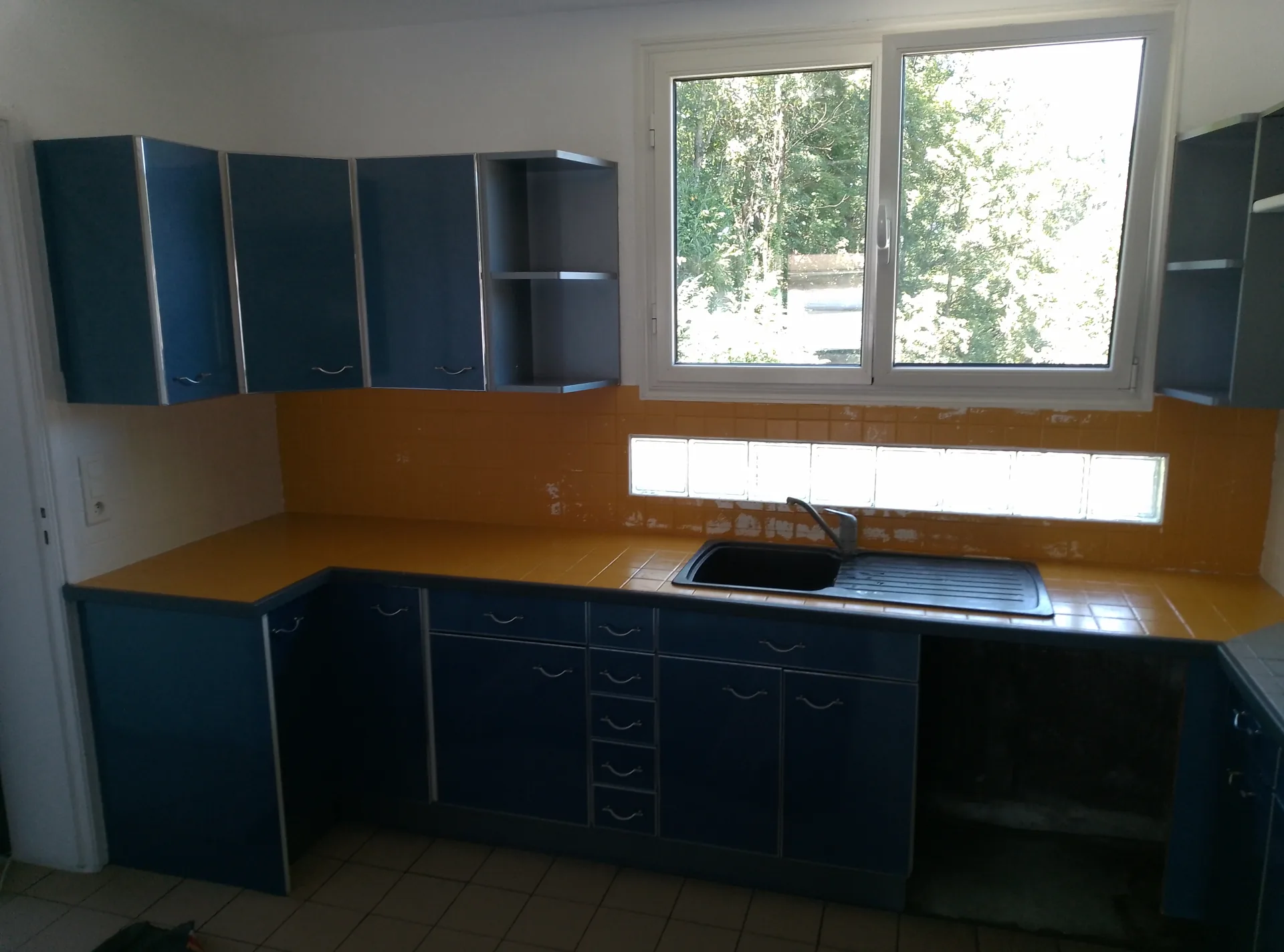 Before: the worktops and splashback in yellow-painted tiles