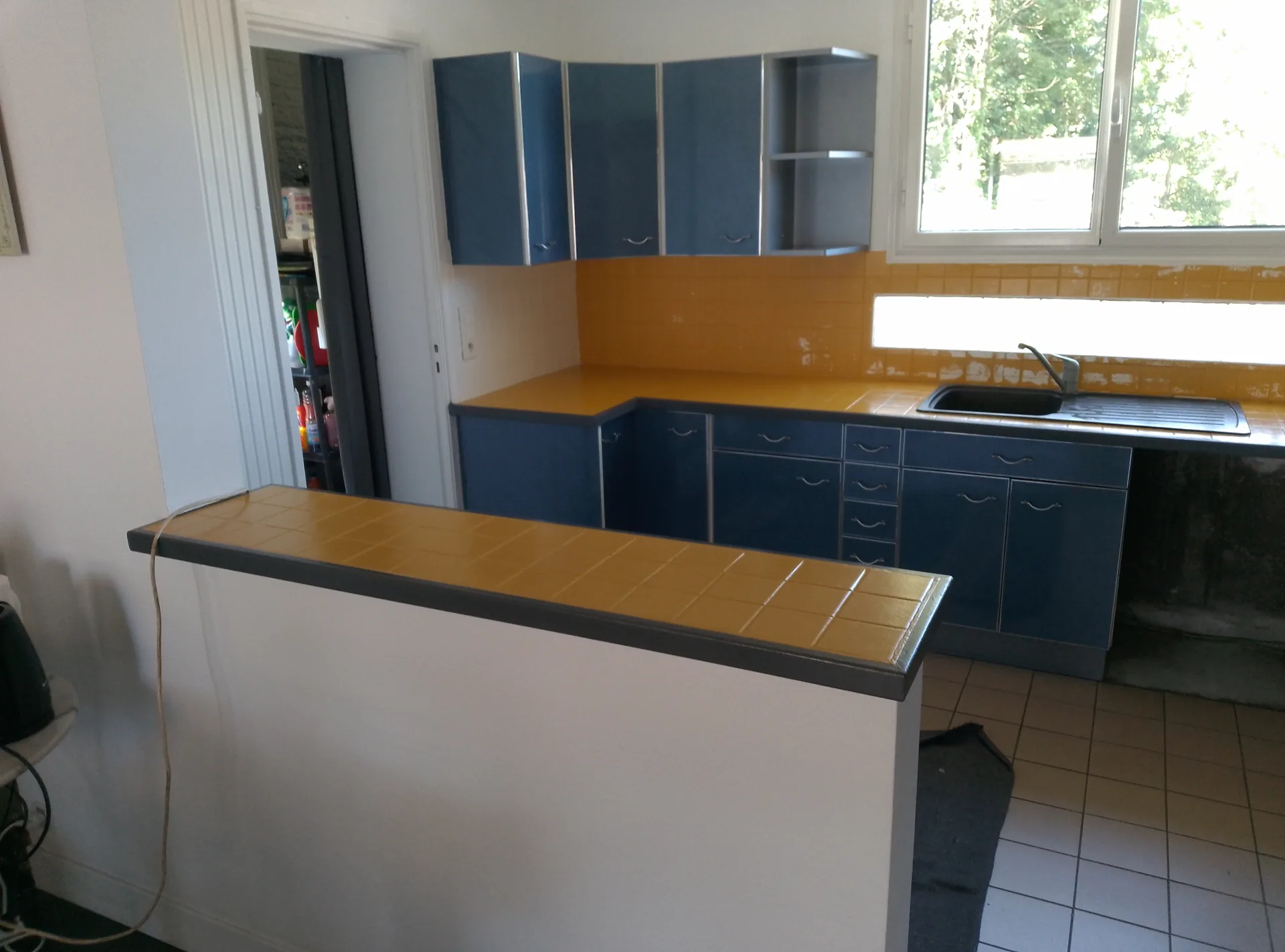 Before: the serving hatch and its yellow tiled top, on the living-room side