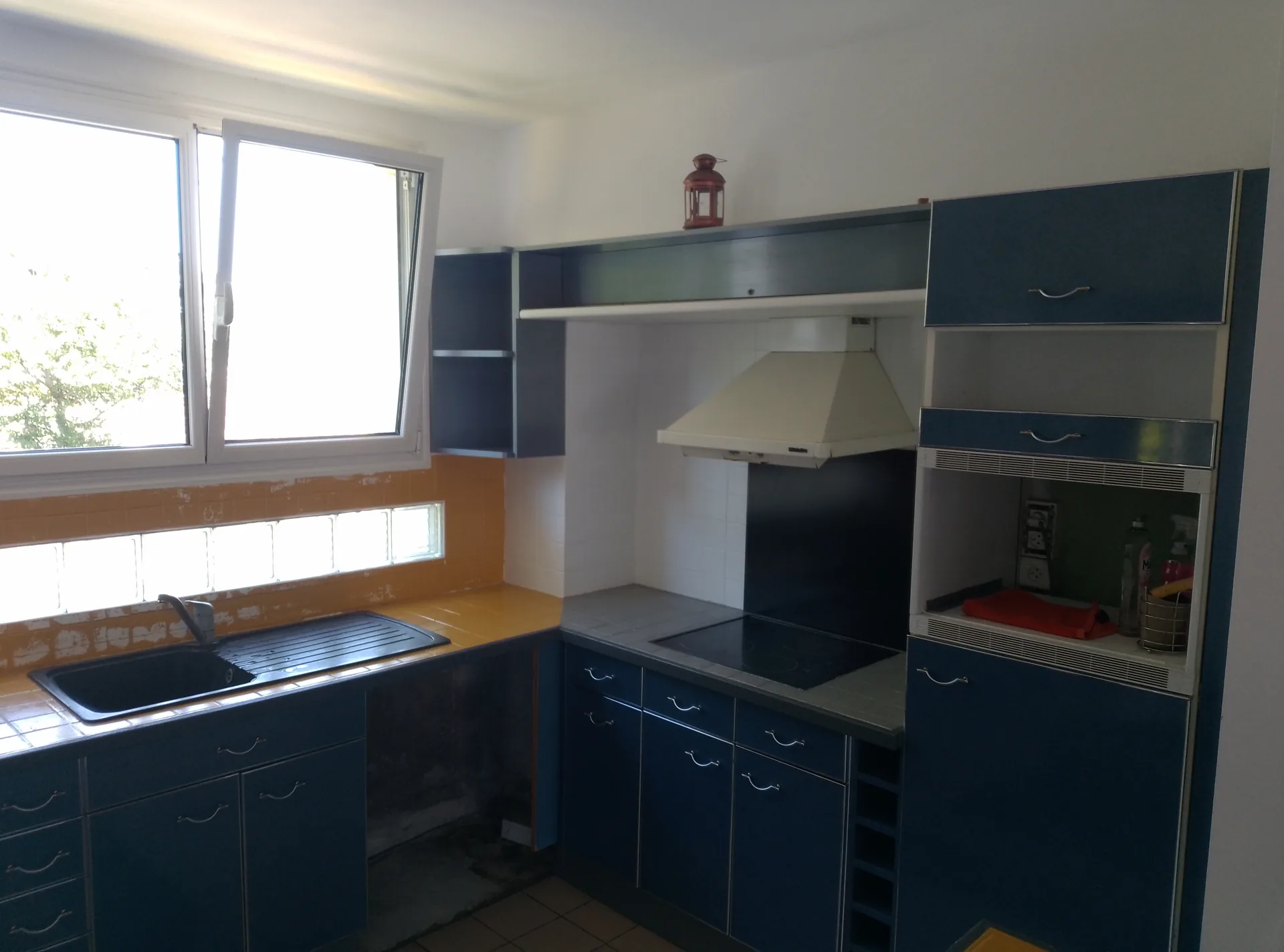 Before: the cooking corner and its yellow tiles around the hood
