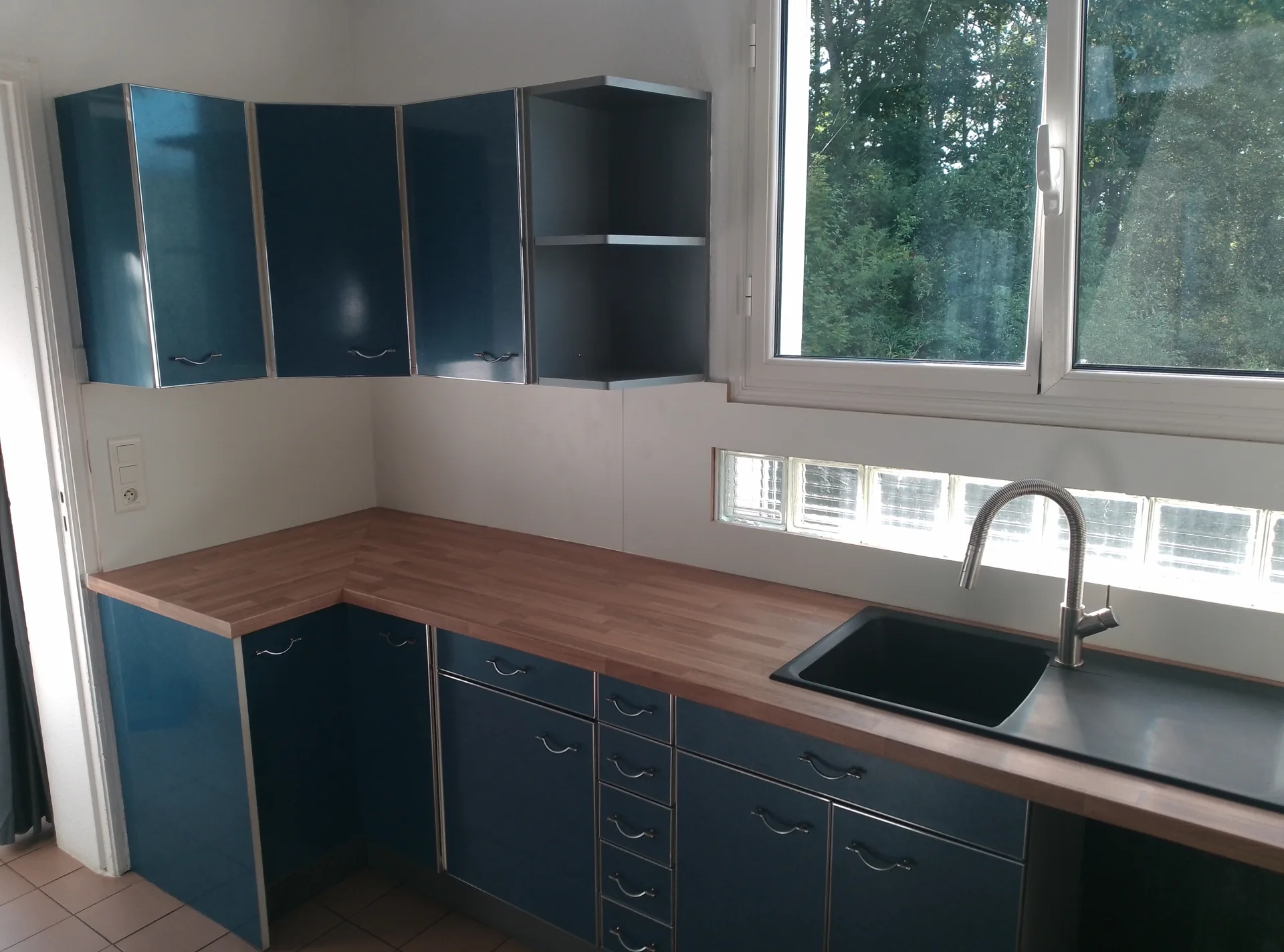 The new oak-effect worktop, the black sink and the mixer tap, under the glass panes kept in place