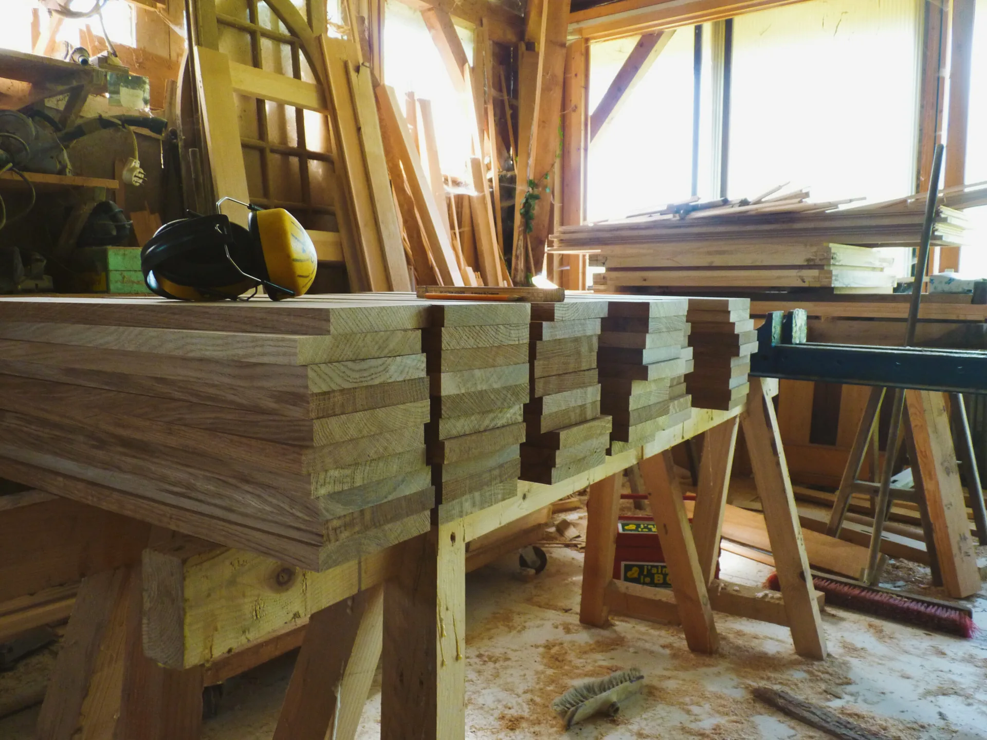 Workshop fabrication: the chocolate-toned oak treads stacked on the bench