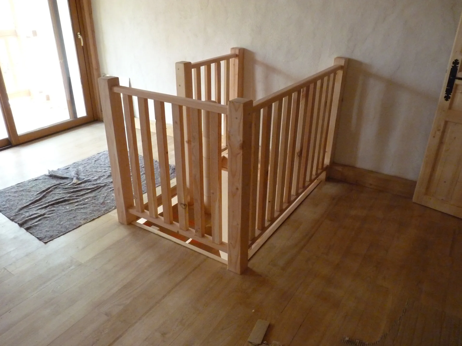 The Douglas fir guard rail running around the stairwell opening, on the sweet chestnut floor upstairs
