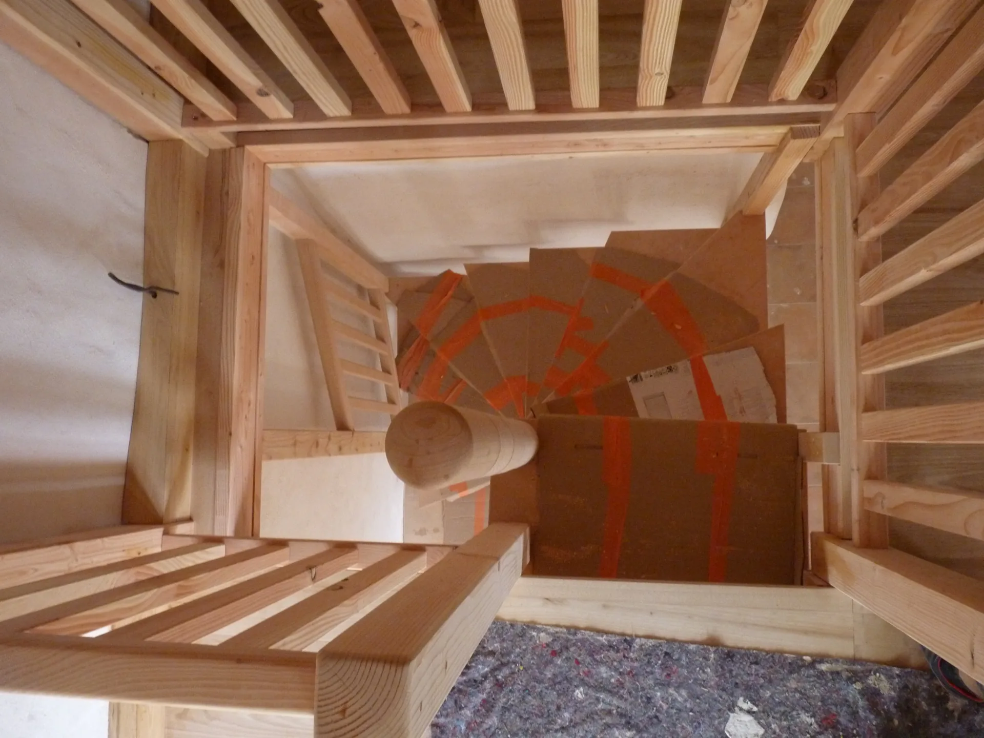 Looking down through the stairwell opening: the spiral staircase seen through the railing balusters