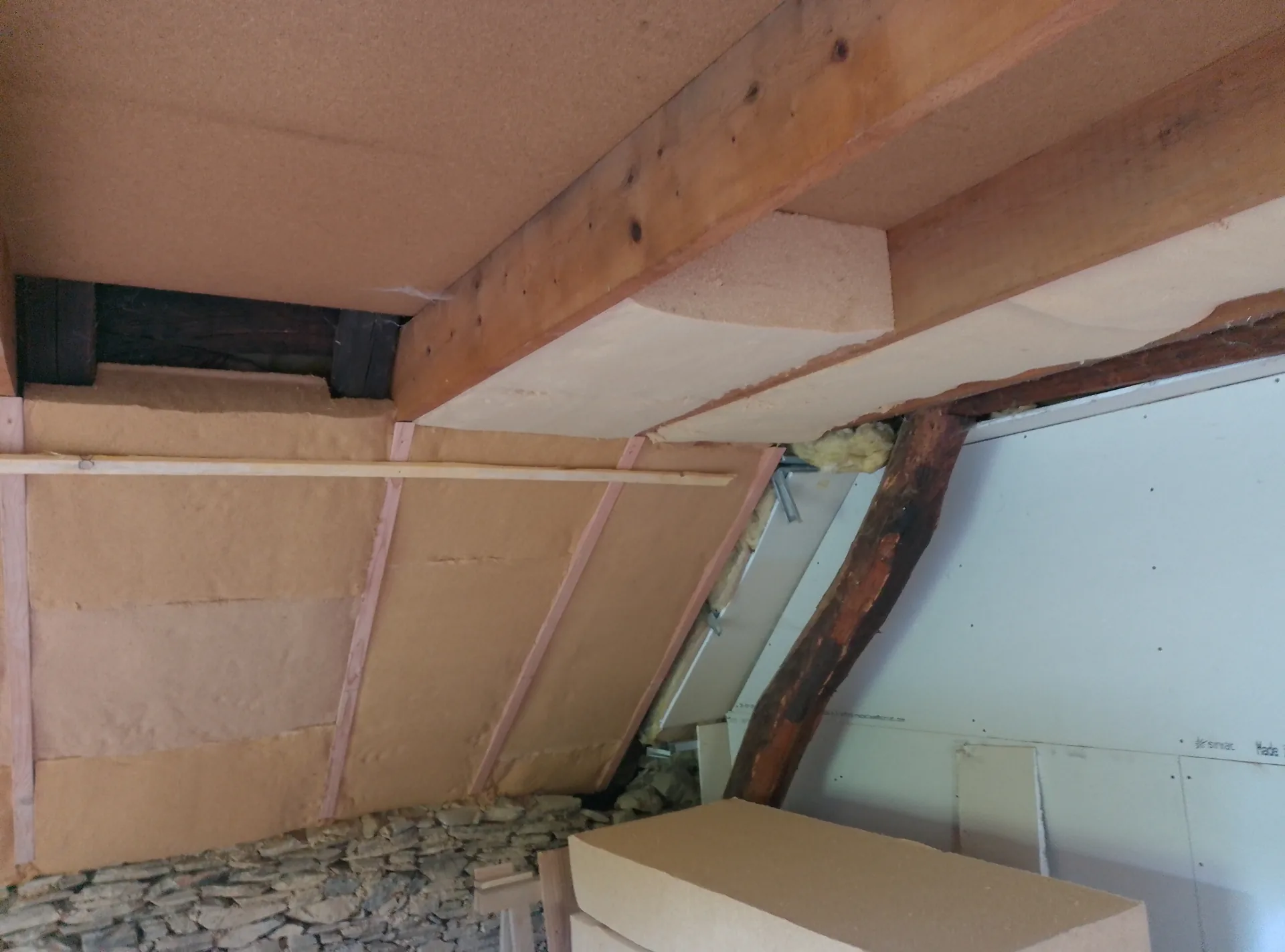 Wood-fibre insulation fitted in the sloping ceilings, between the old beams