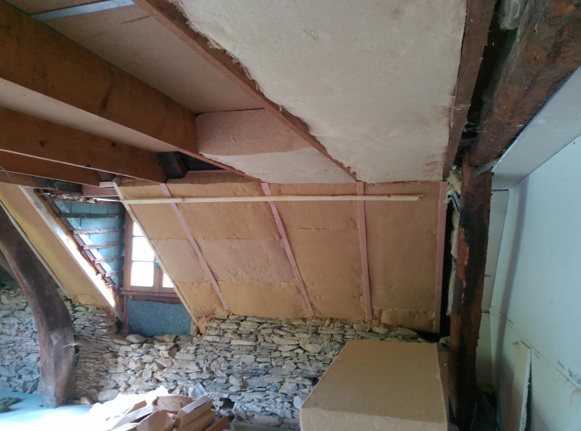 The sloping-ceiling insulation above the original stone walls