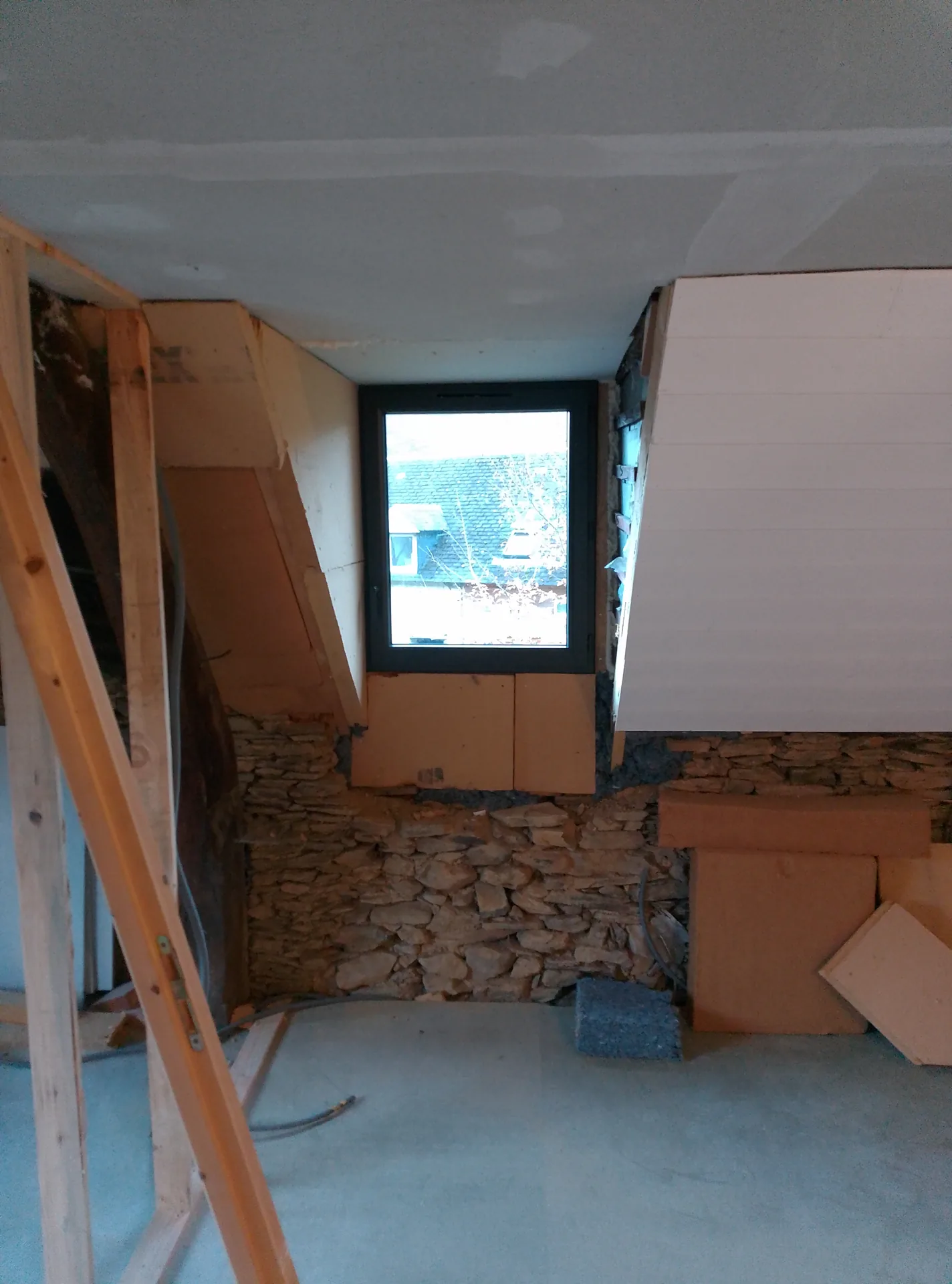 An upstairs window between the sloping ceilings being faced