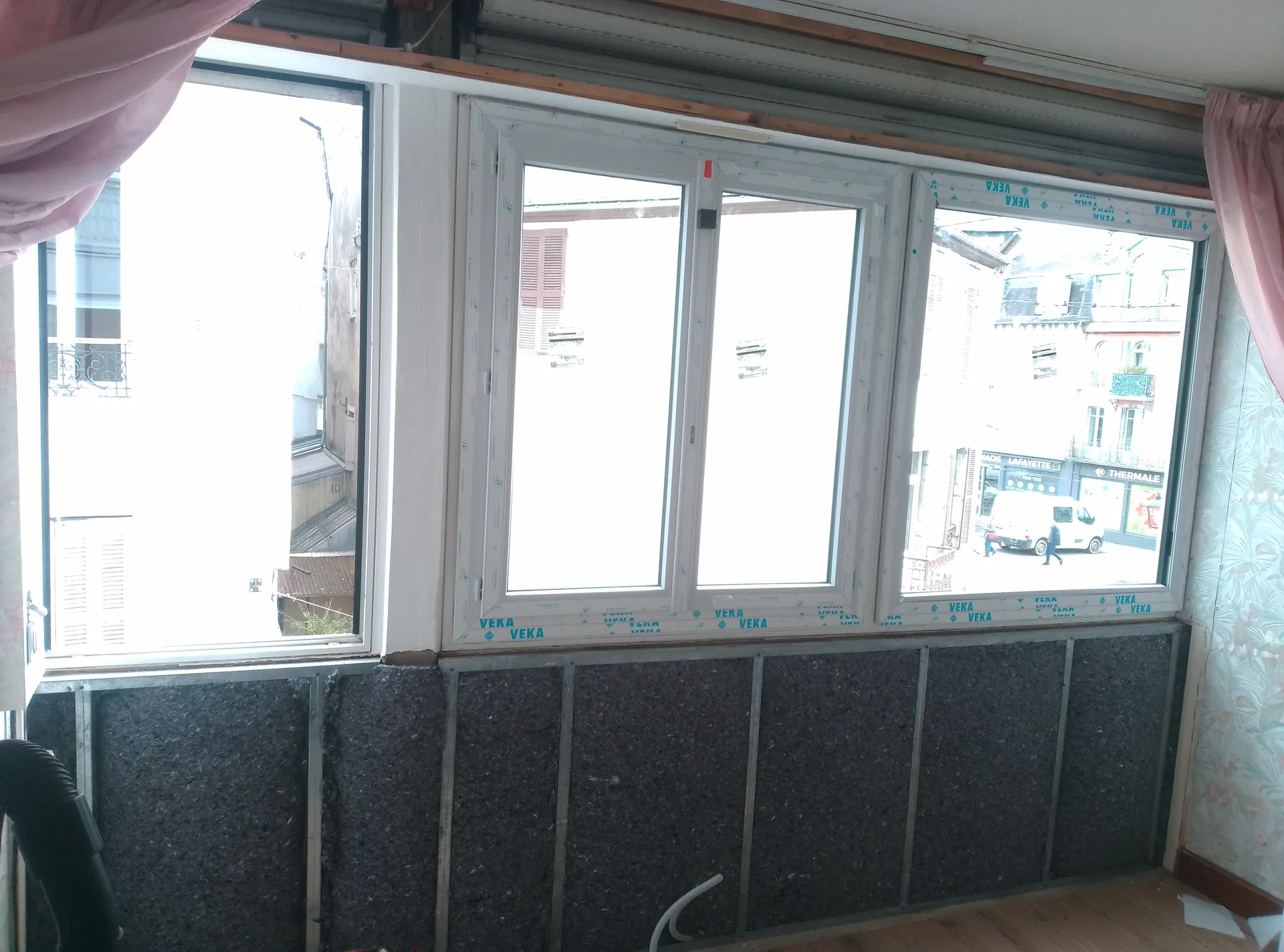 During the work: uPVC windows fitted and insulation between the rails at the base of the wall, before boarding