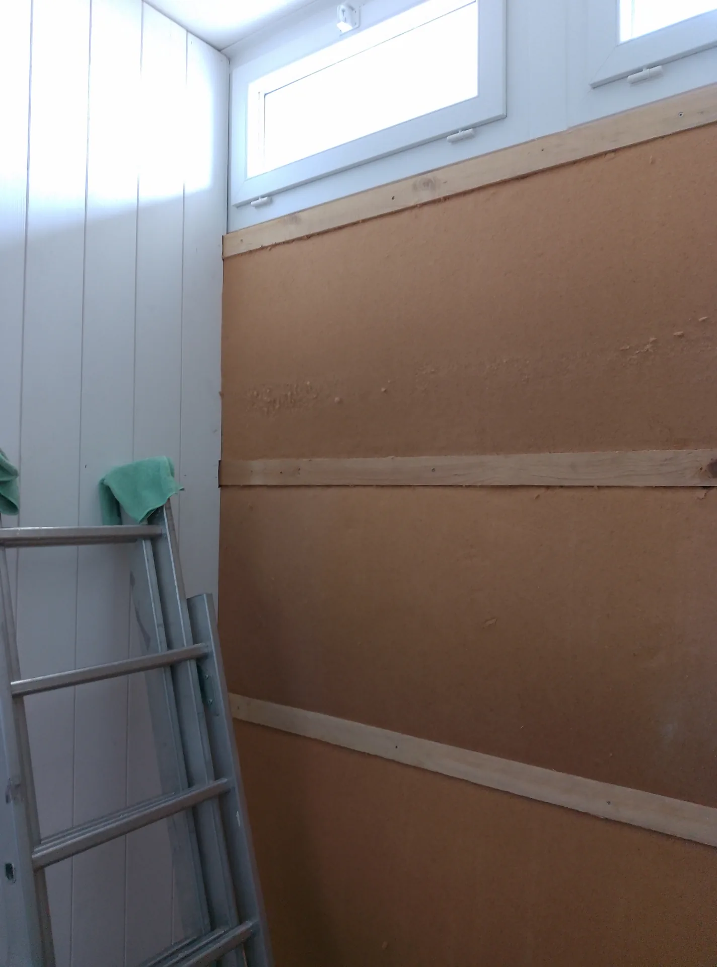 The wood fibre panels fitted, next to the white panelling already in place