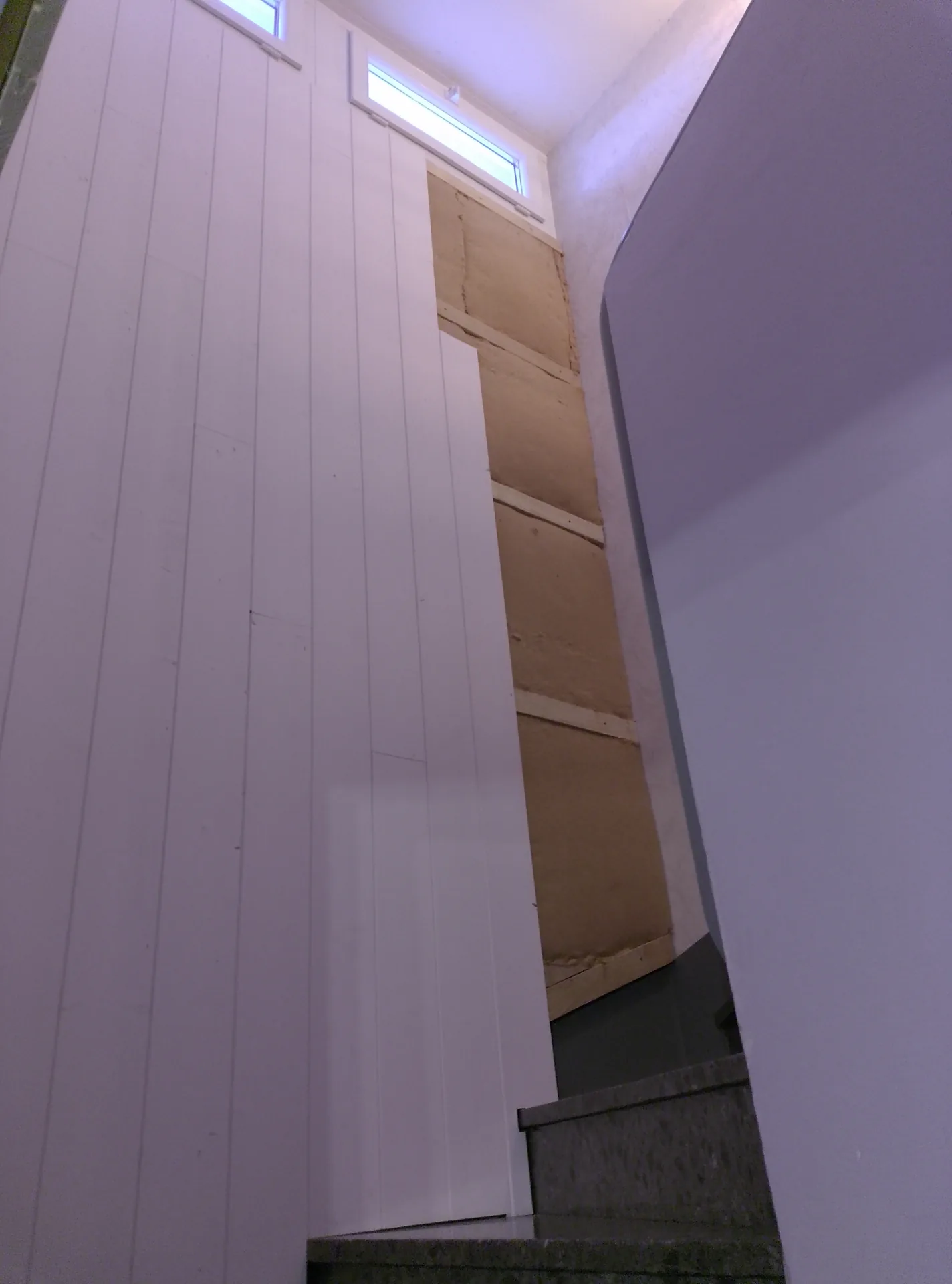 The staircase wall being lined: panelling fitted on one side, wood fibre on the other