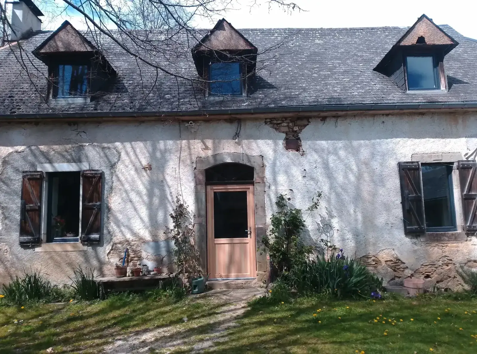 Farmhouse facade with a new pine door and replaced windows