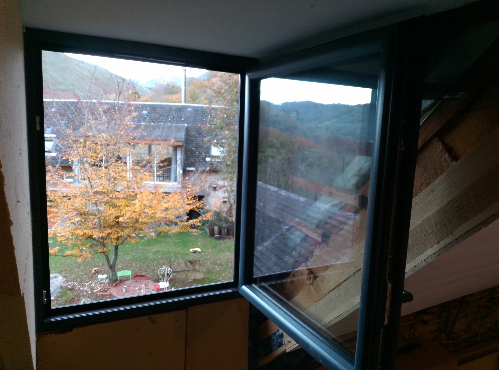 Anthracite grey uPVC window open onto the garden, during the works