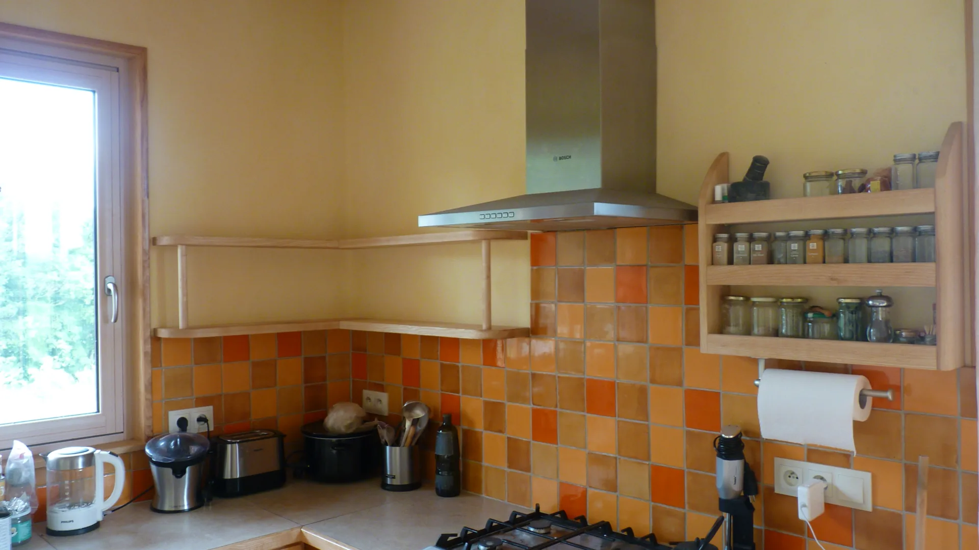 The corner of the kitchen: a shelf on invisible fixings along the wall and an ash spice cabinet