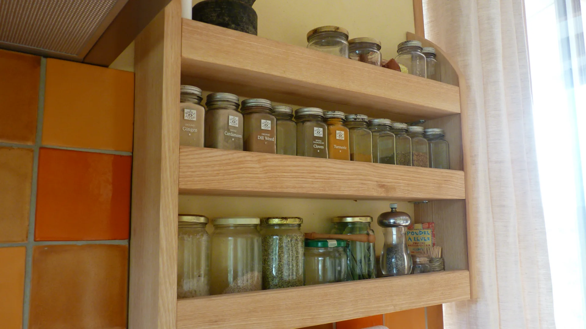The solid ash spice cabinet, filled with jars on three levels