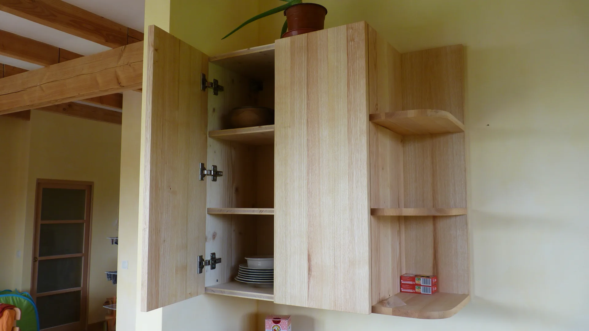 The wall cabinet open: Blum hinges and storage on two levels