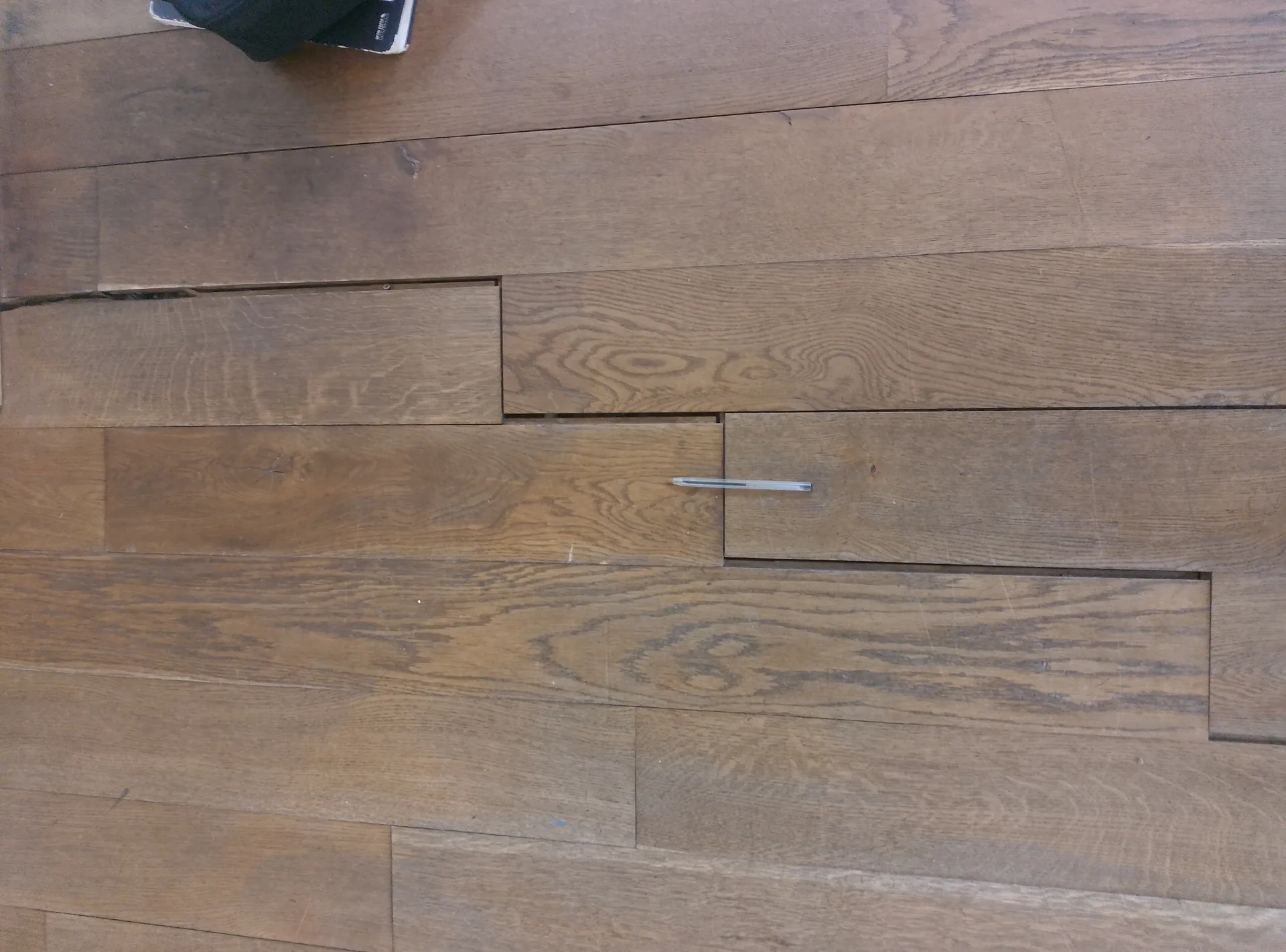 Before the work: cracked, distorted oak boards with an exposed nail