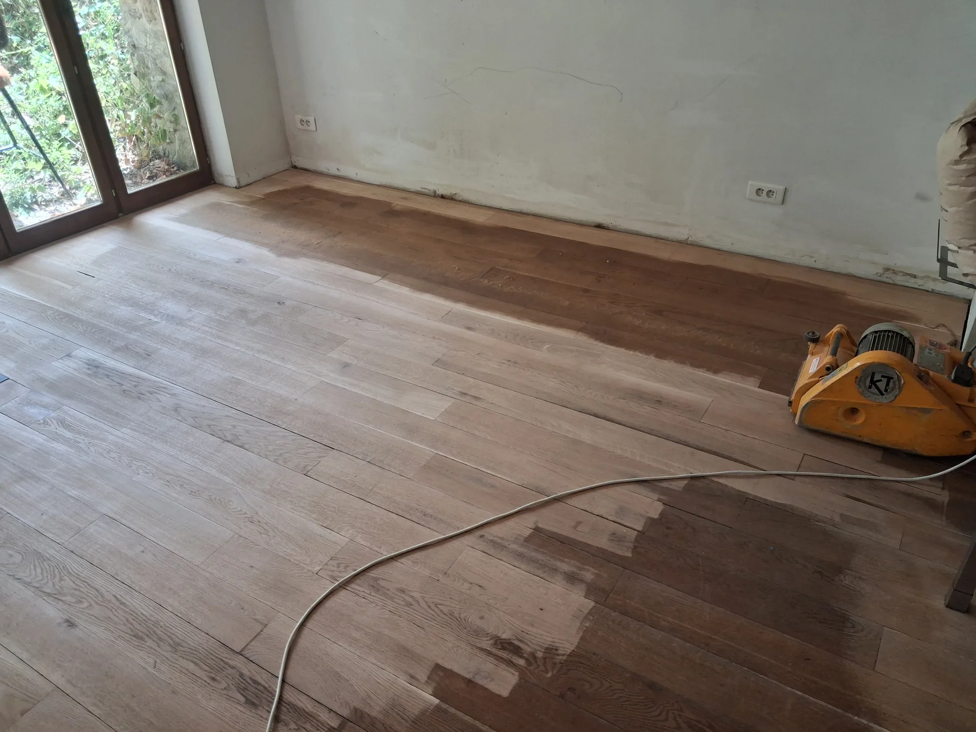 Sanding back in progress: the contrast between bare oak and the old finish