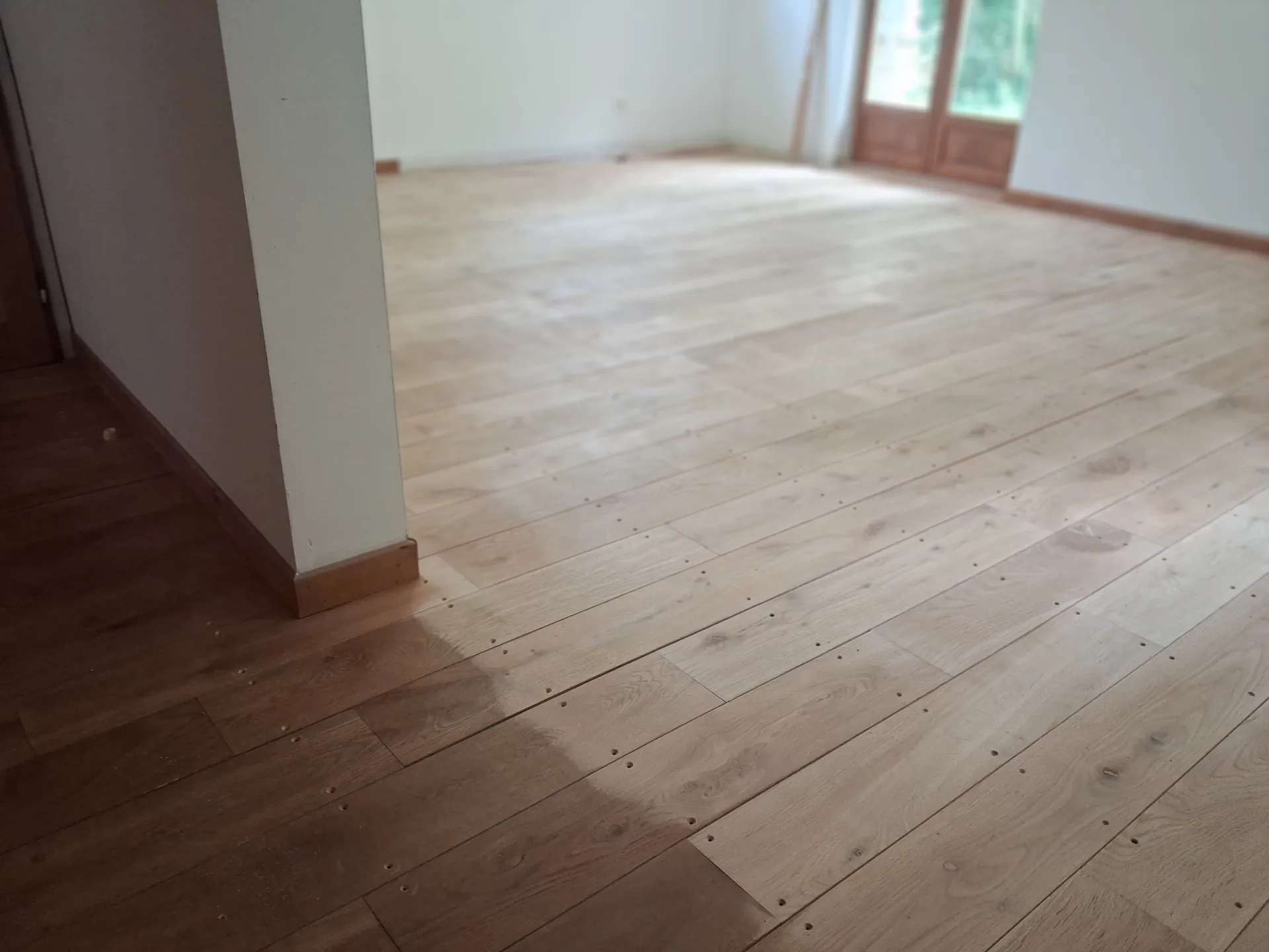 Oak boards re-screwed from above, screw heads still visible before filling