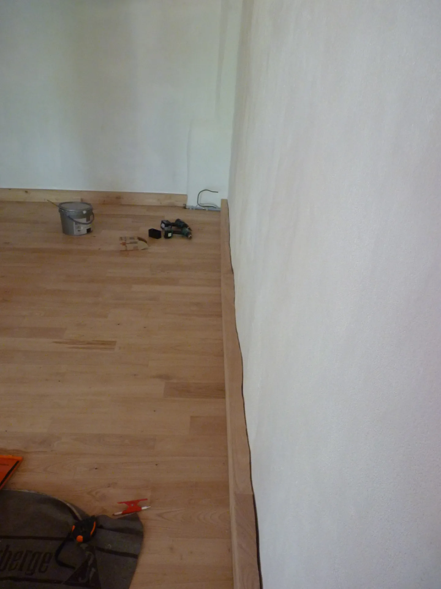 The sweet chestnut skirting following the curve of the uneven wall, without a single gap