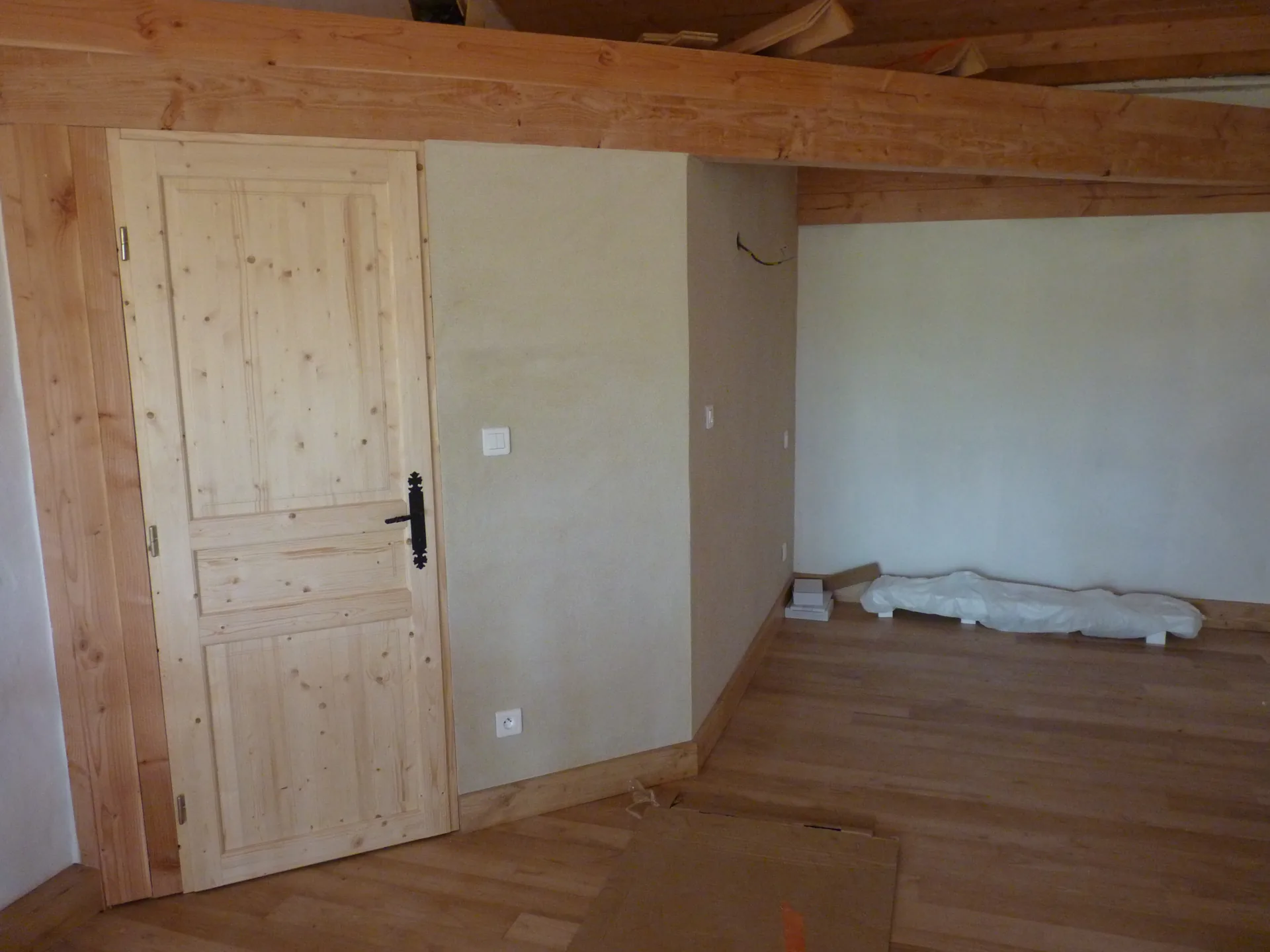 The completed room: sweet chestnut floor, matching skirtings and a wooden door under the joists
