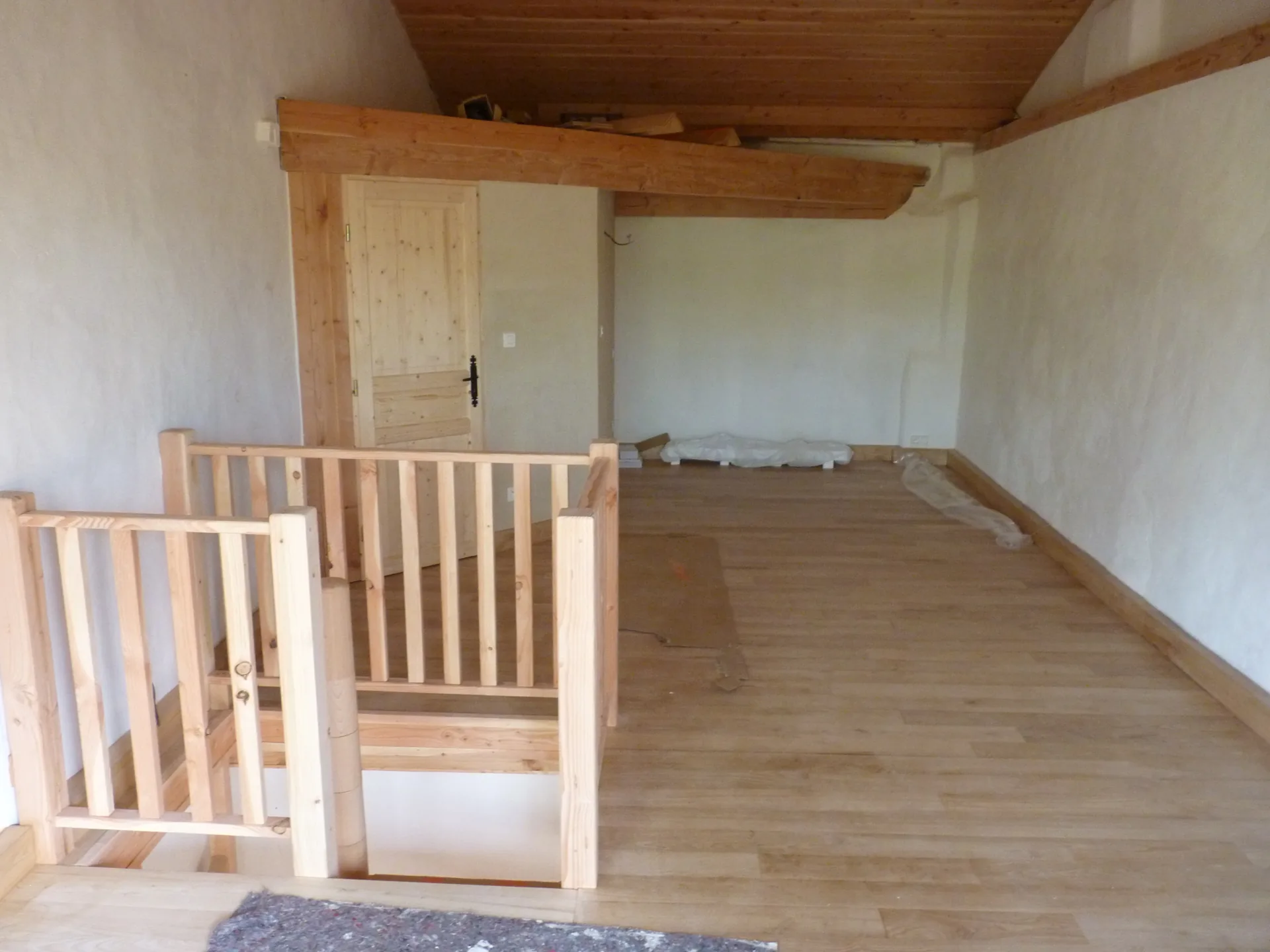 The finished room: the sweet chestnut floor and, at the far end, the top of the staircase and its railing