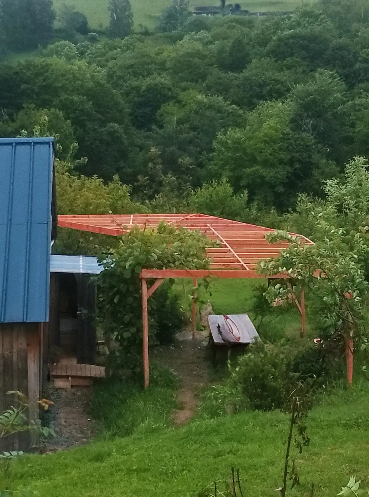 Overall view of the multi-section pergola, leaning against the existing building on sloping ground