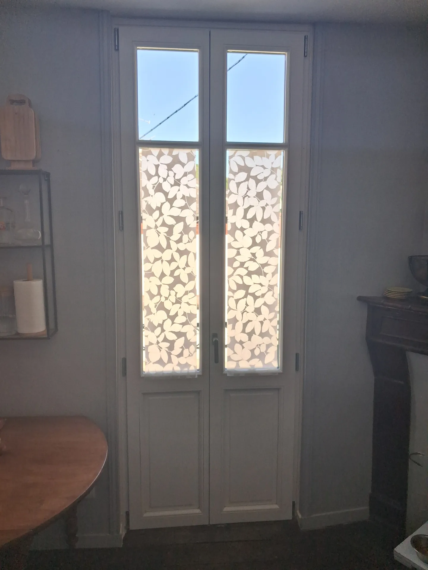 The new French doors lacquered white on the kitchen side, with their solid lower panel