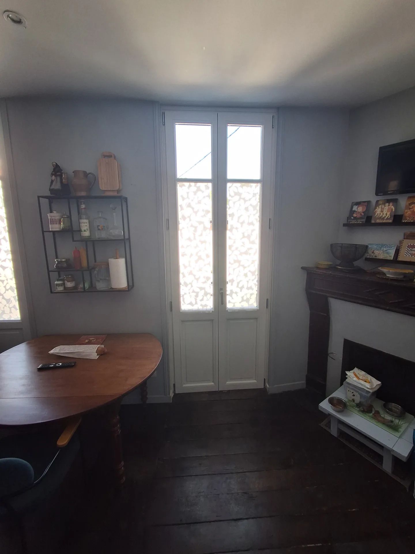 The kitchen with the new French doors, between the table and the fireplace