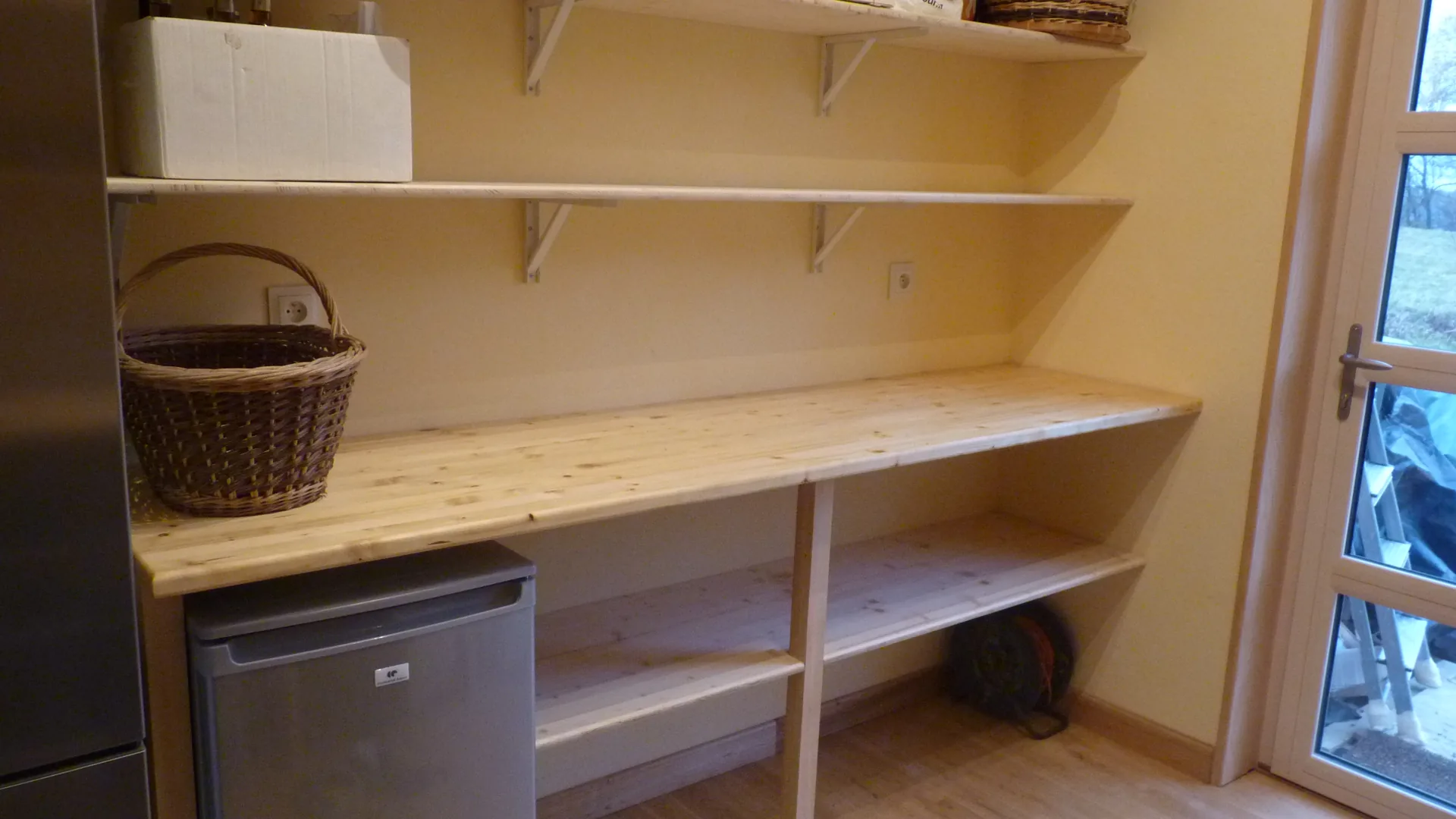 The solid spruce worktop and the pantry shelves, fitted to the rendered walls