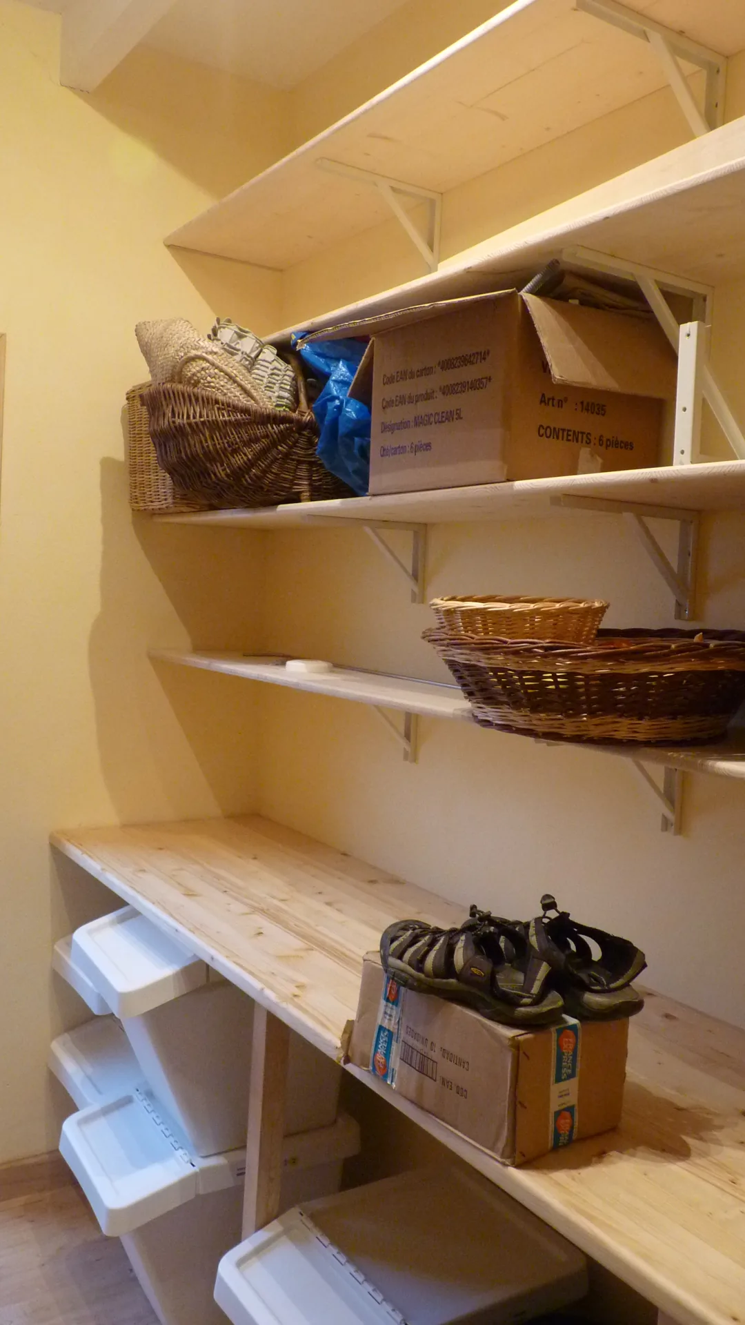 The pantry shelves loaded with baskets and boxes, above the spruce worktop