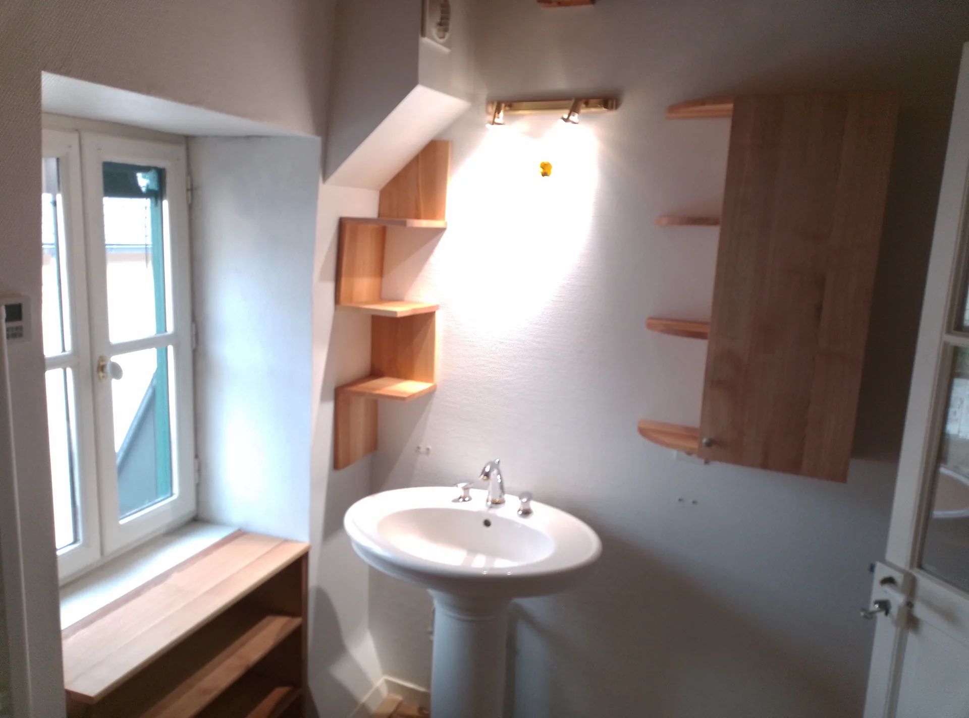 Overview of the bathroom: stepped shelf unit, pedestal basin, unit below the window and ash wall cabinet