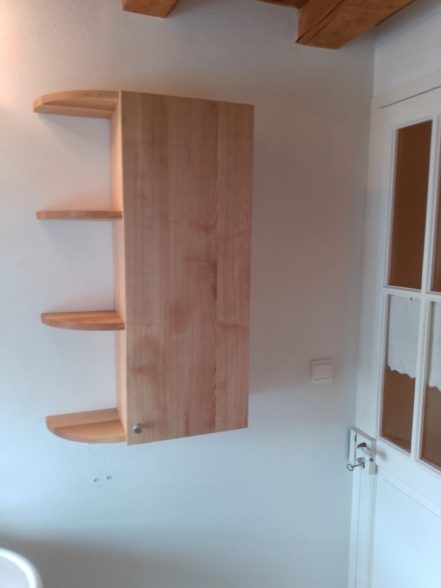 The wall cabinet closed: solid ash door and open shelves with rounded noses